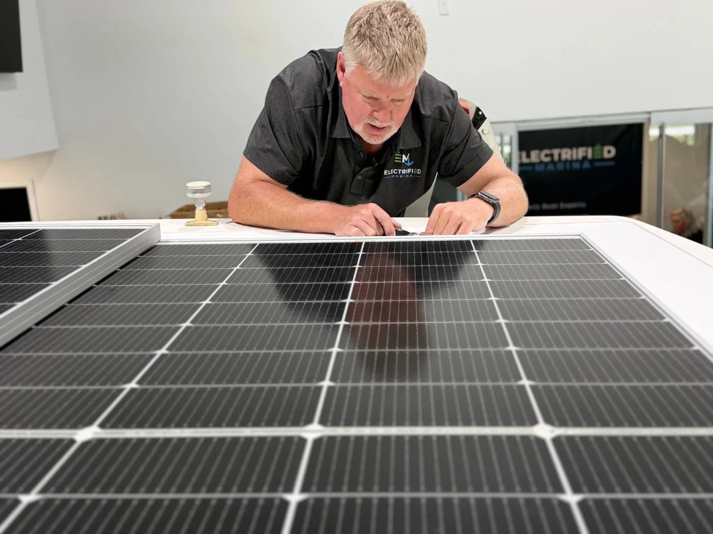 Technician preparing a solar panel in the marina workshop
