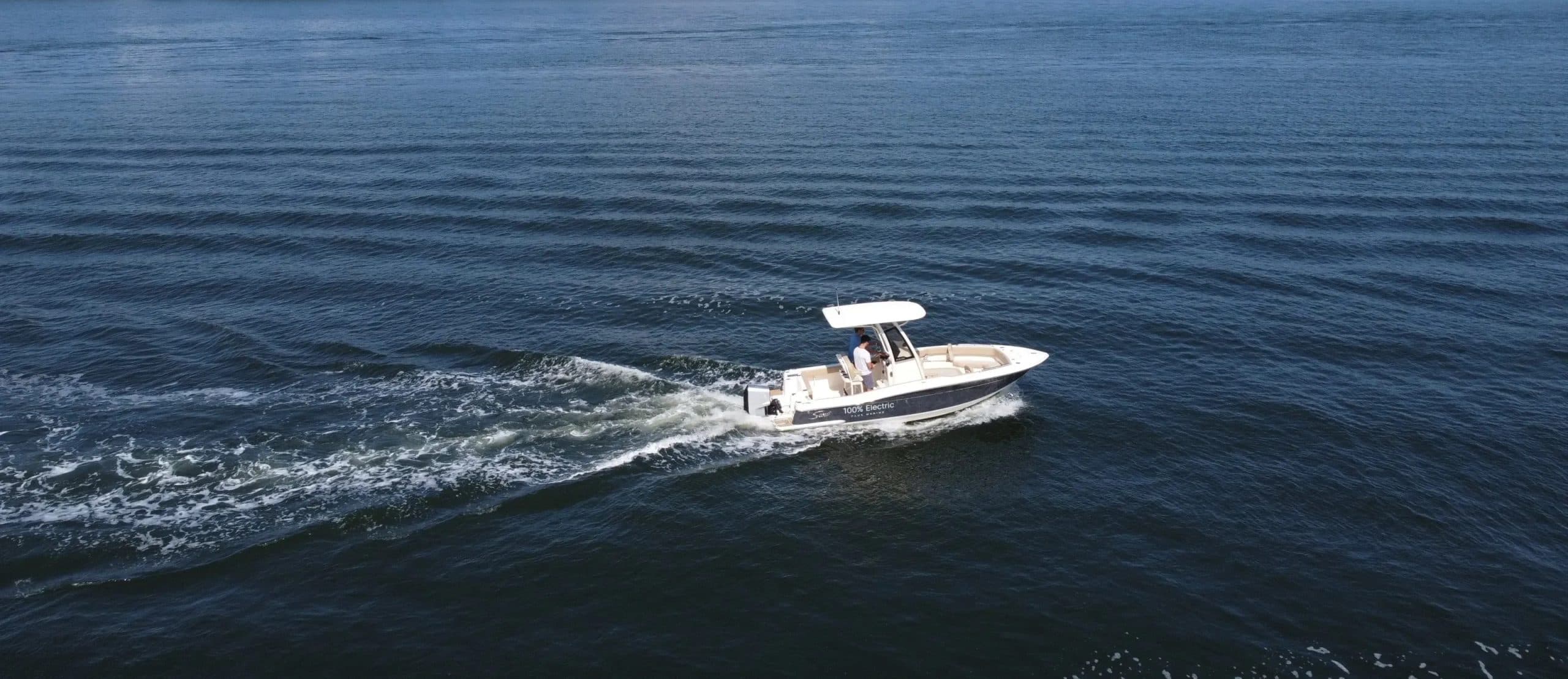 Scout 215 XSF center-console boat cruising across open water, leaving a foamy wake.